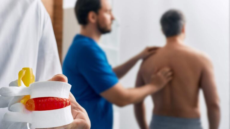 Doctor helping patient with herniated disc vs surgery